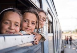 Drei Kinder schauen aus Zugfenster
